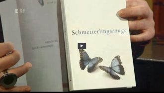 Das Buch Schmetterlingstango von Georg Magirius in der Sendung LesBAR des ERF. Zwei Schmetterlinge sind auf dem Cover zu sehen, einer auf dem Transparentumschlag. Das Buch sei ein geheimnisvoller Tango, urteilt Ute Heuser-Ludwig. 